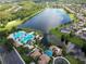 Overhead view features the community's pool, clubhouse, lake, and surrounding residences at 9053 Lee Vista Blvd # 1404, Orlando, FL 32829