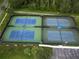 Aerial view of four community tennis courts with blue surface, green borders, black fencing, and covered benches at 9053 Lee Vista Blvd # 1404, Orlando, FL 32829