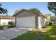 Home's two-car garage featuring stone accents and a well-maintained lawn at 10519 Wyndcliff Dr, Orlando, FL 32817