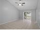 Bright, open living area with tile floors, vaulted ceilings, a ceiling fan, and a sliding glass door at 10519 Wyndcliff Dr, Orlando, FL 32817