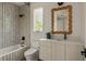 Bathroom featuring patterned shower, white vanity with a decorative mirror, and natural light at 1150 Via Salerno, Winter Park, FL 32789