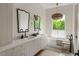 Bright bathroom features double sinks, soaking tub, and large window with greenery at 1150 Via Salerno, Winter Park, FL 32789