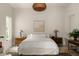 Neutral bedroom with wicker lighting, matching night stands and a decorative rug at 1150 Via Salerno, Winter Park, FL 32789