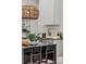 An eye-level view of a dark gray kitchen island with a wooden light fixture at 1150 Via Salerno, Winter Park, FL 32789
