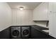Well-organized laundry room with modern washer and dryer units and sleek black countertops at 1150 Via Salerno, Winter Park, FL 32789