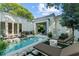 Stunning backyard pool area with a guest house, lounge furniture, and beautiful landscaping at 1150 Via Salerno, Winter Park, FL 32789