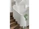 Modern staircase featuring natural wood steps, a curved white wall, and abundant natural light at 1150 Via Salerno, Winter Park, FL 32789