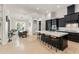 Open-concept kitchen featuring a large center island with seating, stainless steel appliances, and a sunlit dining area at 11754 Waterstone Loop Dr, Windermere, FL 34786