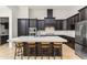 Beautiful kitchen with dark wood cabinets, stainless steel appliances, an oversized island with seating, and marble backsplash at 11754 Waterstone Loop Dr, Windermere, FL 34786