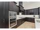 Modern kitchen featuring dark wood cabinetry, stainless steel appliances, and marble countertops at 11754 Waterstone Loop Dr, Windermere, FL 34786