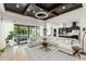 Spacious living room with a large sectional couch, travertine floors, and seamless access to the kitchen and outdoor pool at 11754 Waterstone Loop Dr, Windermere, FL 34786