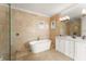 Bright main bathroom with a freestanding bathtub, tile flooring, and a double vanity at 11754 Waterstone Loop Dr, Windermere, FL 34786
