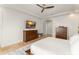 Bright main bedroom with a ceiling fan, tile floors, a TV, and natural light with a view of the en suite bathroom at 11754 Waterstone Loop Dr, Windermere, FL 34786