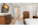 Bright main bedroom with tile floors, a TV, and natural light with a view of the en suite bathroom at 11754 Waterstone Loop Dr, Windermere, FL 34786