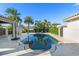Backyard pool area surrounded by lush landscaping, including palm trees, with a covered patio and summer kitchen nearby at 11754 Waterstone Loop Dr, Windermere, FL 34786