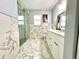 Bright bathroom with a glass-enclosed shower, marble tile, and double vanity at 1212 Bradwell Dr, Orlando, FL 32837