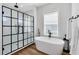 Modern bathroom features a freestanding tub, walk-in shower with black trim, and shiplap walls at 1410 W New Hampshire St, Orlando, FL 32804