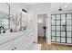 Bright bathroom features double vanity, wood-look tile floors, and glass-enclosed shower with black trim at 1410 W New Hampshire St, Orlando, FL 32804