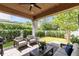 Charming covered patio includes cushioned seating, a ceiling fan, and a lush green backyard at 1410 W New Hampshire St, Orlando, FL 32804