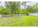 Fenced backyard featuring lush green grass and mature trees offers a private outdoor space at 1639 Balsam Willow Trl, Orlando, FL 32825