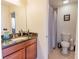 Well-lit bathroom with a granite-topped vanity, decorative mirror, and a shower with a curtain at 1639 Balsam Willow Trl, Orlando, FL 32825