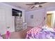 bedroom with wooden dresser, large screen TV, and doorway to bathroom at 1639 Balsam Willow Trl, Orlando, FL 32825