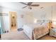 Bright bedroom featuring a ceiling fan, neutral walls, and access to an en-suite bathroom at 1639 Balsam Willow Trl, Orlando, FL 32825
