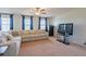 Living room with large sectional, plush carpet, blue curtains and a television at 1639 Balsam Willow Trl, Orlando, FL 32825