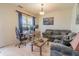 Cozy living room featuring a sofa and desk, illuminated by natural light through a window at 1639 Balsam Willow Trl, Orlando, FL 32825