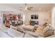 Cozy living room with a large sectional sofa, mounted TV, and open access to the dining area and kitchen at 1639 Balsam Willow Trl, Orlando, FL 32825