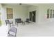 Covered patio features neutral colors, dark metal outdoor furniture, and sliding glass doors for easy access to inside at 1639 Balsam Willow Trl, Orlando, FL 32825