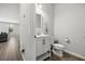 This half bathroom features a modern vanity, toilet, and stylish design with a window view to the living area at 16564 Silversaw Palm Dr, Winter Garden, FL 34787