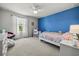 Charming bedroom with a blue accent wall, decor and a comfortable bed at 16564 Silversaw Palm Dr, Winter Garden, FL 34787