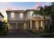 Two-story home with neutral siding, a brick driveway, and a covered front porch at 16564 Silversaw Palm Dr, Winter Garden, FL 34787