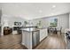 Open-concept kitchen flows into the living area with a granite island and stainless steel dishwasher at 16564 Silversaw Palm Dr, Winter Garden, FL 34787