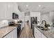 Bright kitchen featuring granite countertops, stainless steel appliances, and white cabinets with modern hardware at 16564 Silversaw Palm Dr, Winter Garden, FL 34787