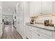 Butler's pantry with granite countertop, white cabinets, and modern lighting in a transitional space at 16564 Silversaw Palm Dr, Winter Garden, FL 34787
