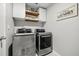 Laundry room featuring modern washer and dryer units with overhead storage at 16564 Silversaw Palm Dr, Winter Garden, FL 34787