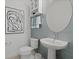 Stylish powder room featuring a pedestal sink, unique tile accent wall, and modern fixtures at 2042 Education St, St Cloud, FL 34771