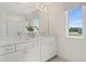 A bright bathroom features double sinks, a large mirror and a window with a view of the neighborhood at 2042 Education St, St Cloud, FL 34771