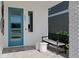 Inviting front porch with stylish seating and a modern teal-colored front door at 2042 Education St, St Cloud, FL 34771