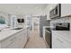 Modern kitchen featuring white cabinets, stainless steel appliances, and a large island with quartz countertops at 2042 Education St, St Cloud, FL 34771