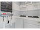 Well-organized laundry room with washer, dryer, and shelving for storage and supplies at 2042 Education St, St Cloud, FL 34771