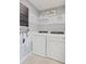 Well-organized laundry room with washer, dryer, and shelving for storage and supplies at 2042 Education St, St Cloud, FL 34771