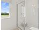 Bright shower enclosure featuring tile walls and glass door with a clear view of the landscape outside the window at 2042 Education St, St Cloud, FL 34771