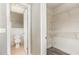 View of a bathroom with white fixtures and tiled walls, connected to a closet with adjustable shelving at 2078 Keyes Ln, Deltona, FL 32738