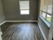 An empty bedroom with grey walls, wood-look floors, and two windows with blinds at 2078 Keyes Ln, Deltona, FL 32738