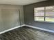 An empty bedroom with grey walls, wood-look floors, and a window with blinds at 2078 Keyes Ln, Deltona, FL 32738