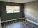 Bright bedroom featuring a window with blinds and stylish wood-look flooring, a perfect retreat at 2078 Keyes Ln, Deltona, FL 32738