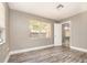 Bedroom with wood-look flooring, neutral gray walls, and natural light at 2078 Keyes Ln, Deltona, FL 32738